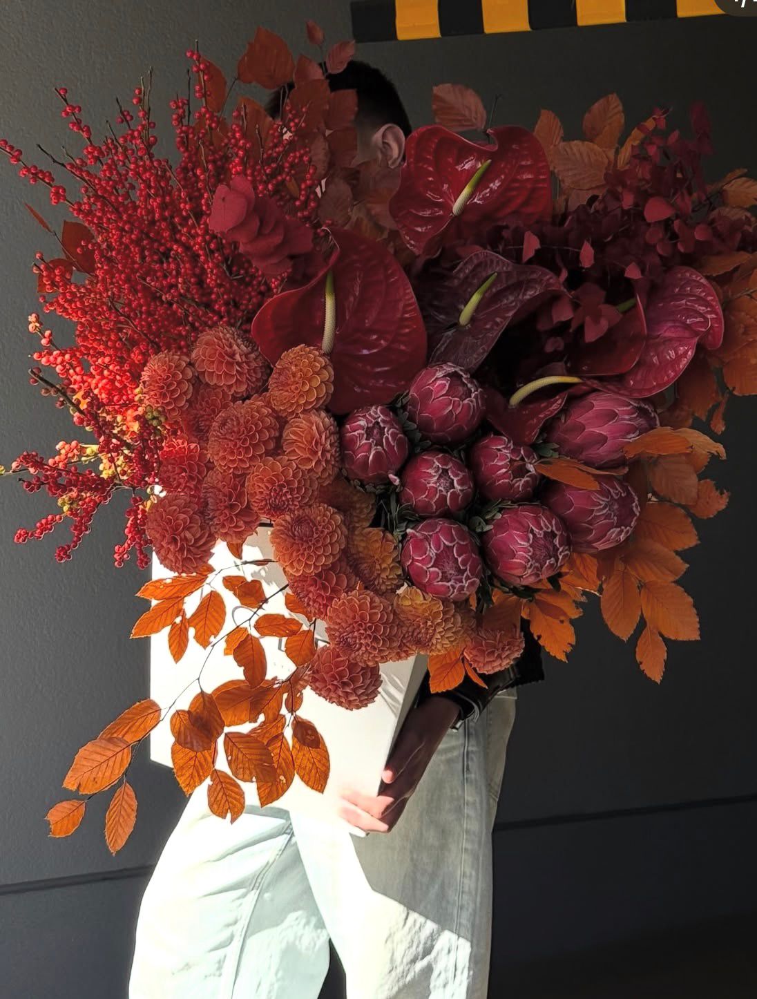Modernes florales Statement-Arrangement an dunkler Wand